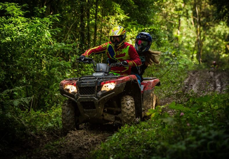 man and woman riding on ATV