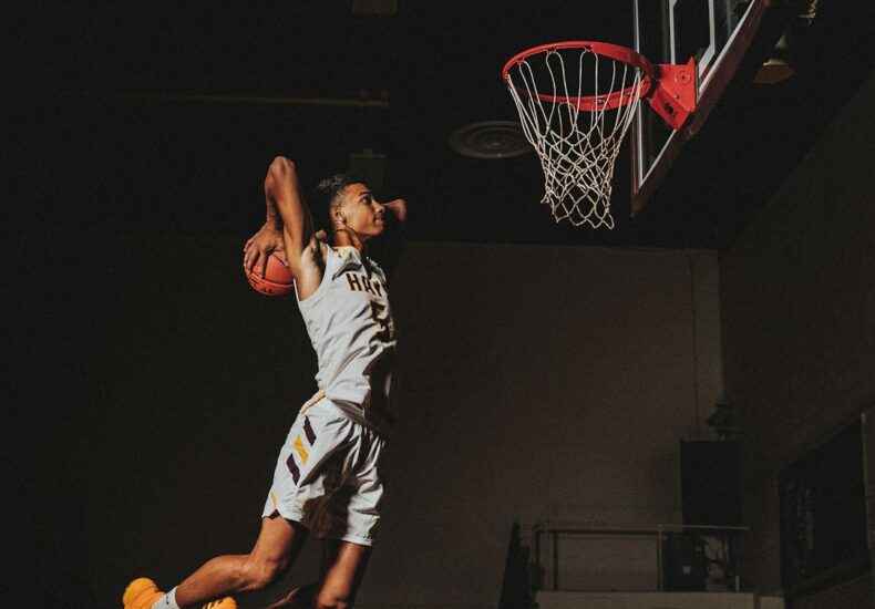2 boys playing basketball on basketball court