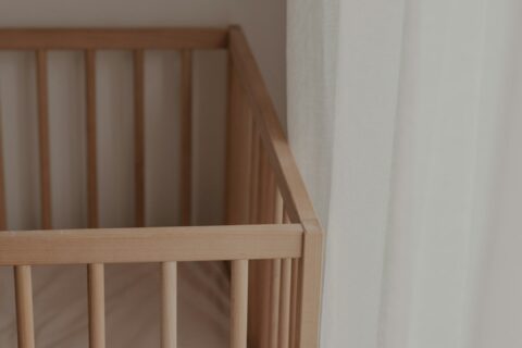 a crib with a white pillow on top of it