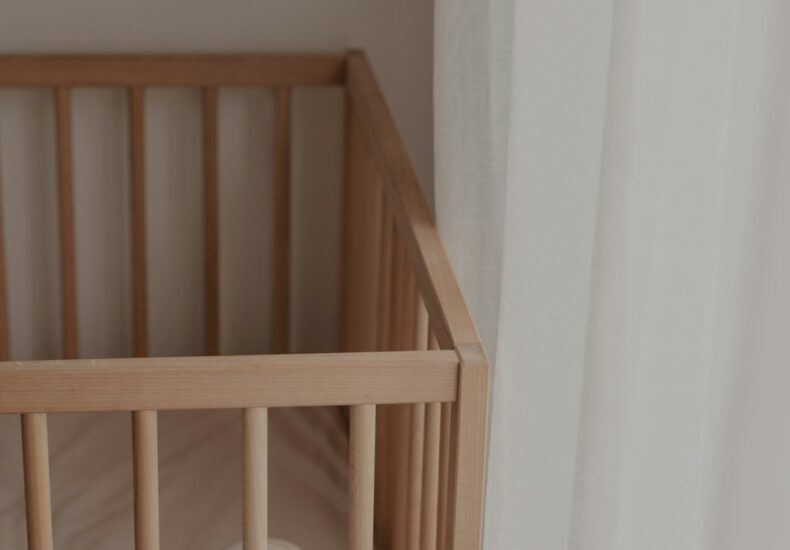 a crib with a white pillow on top of it