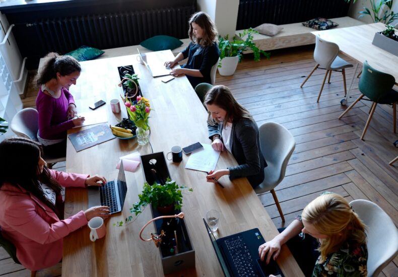 a group of people sitting around a wooden table
