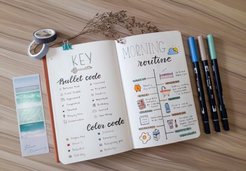 an open book with writing on it next to a pair of scissors