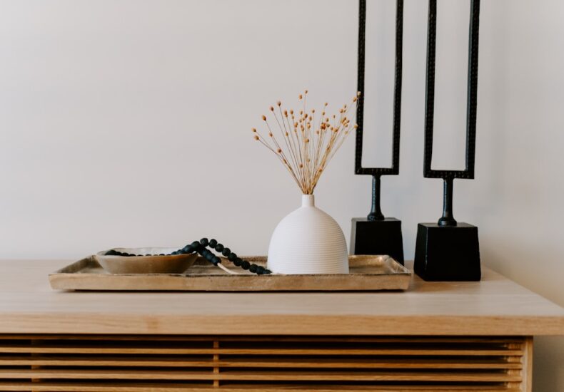 white ceramic vase near two black table decors
