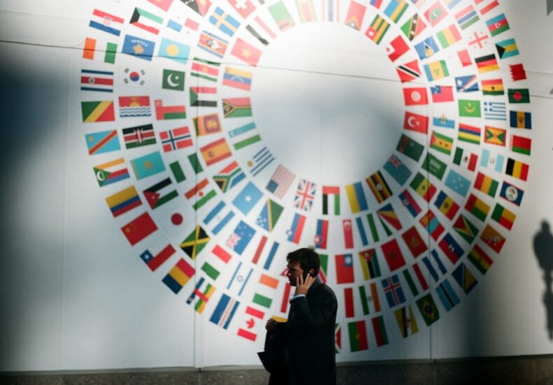 woman in black coat standing near round white red and blue wall