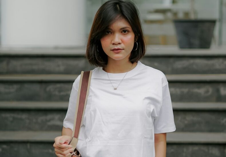 woman in white crew neck t-shirt and brown leather sling bag
