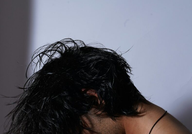 A man with wet hair standing in front of a mirror