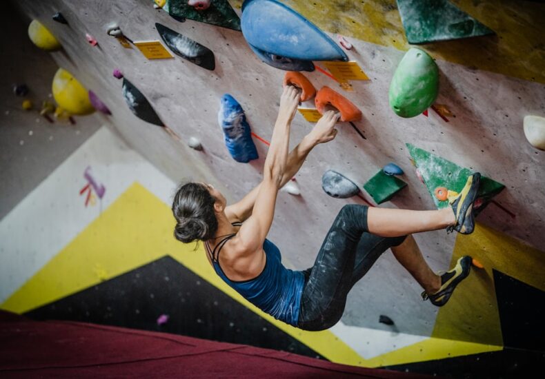 woman rock climbing inside building
