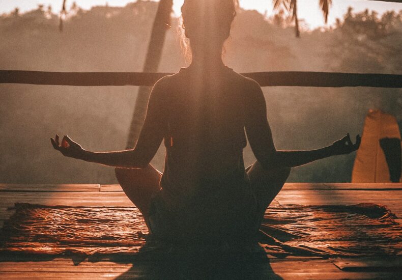 woman doing yoga meditation on brown parquet flooring