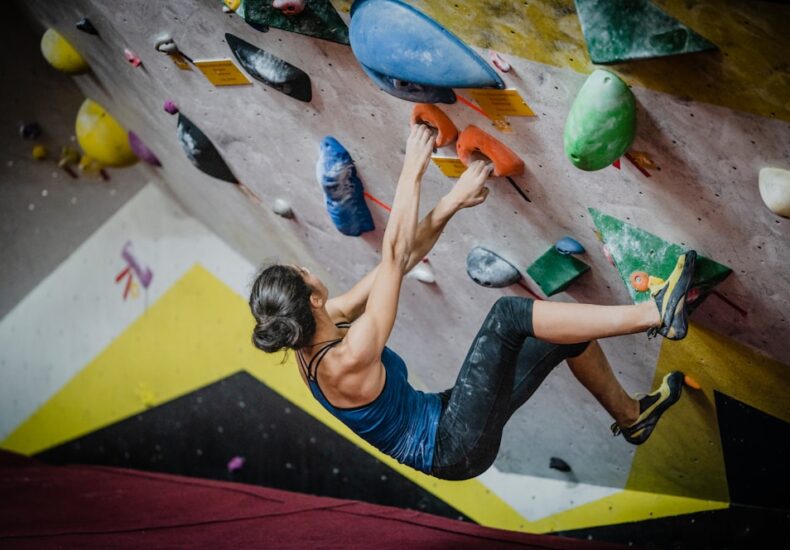 woman rock climbing inside building