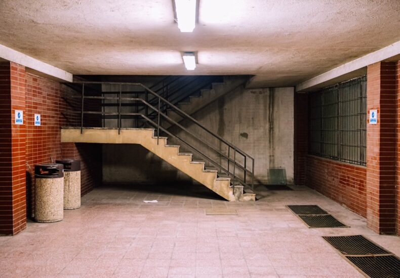 brown concrete staircase with stainless steel railings