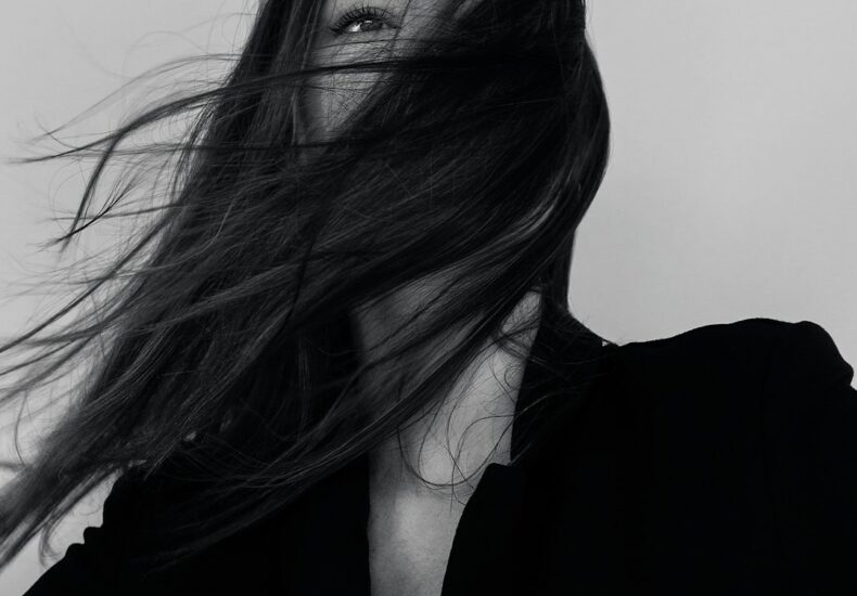 grayscale photography of woman wearing long-sleeved shirt