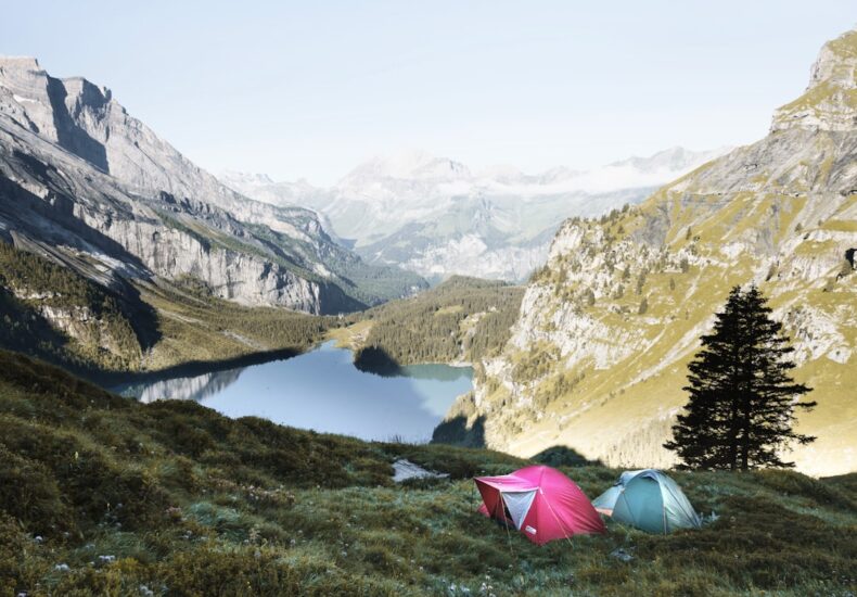 red and gray tents in grass covered mountain