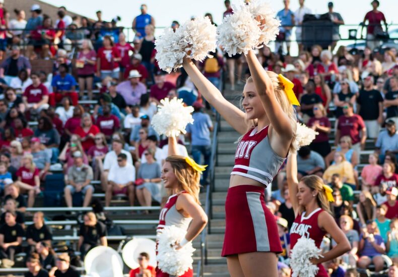 women in white and red uniform dancing on stage during daytime