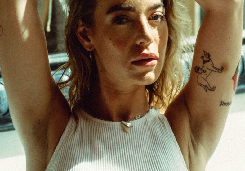 a woman sitting on a bench with her hands behind her head