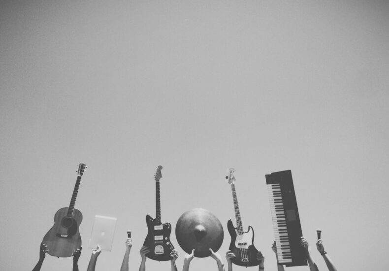 grayscale photo of people holding assorted music instruments