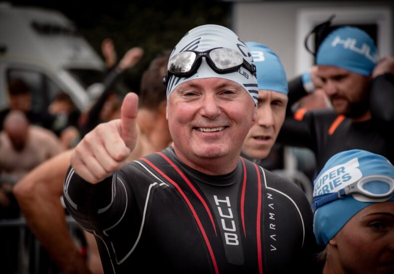 Man in wetsuit gives thumbs up