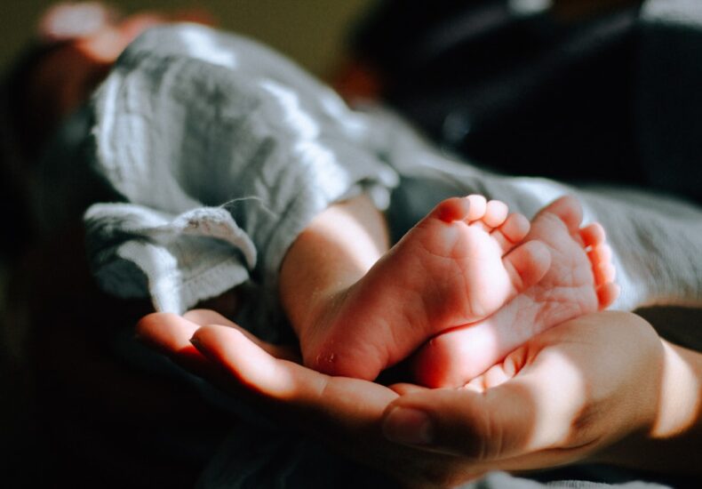 person holding baby feet