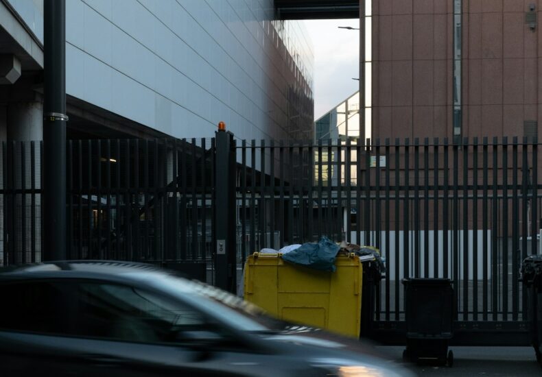 A car driving down a street next to a tall building