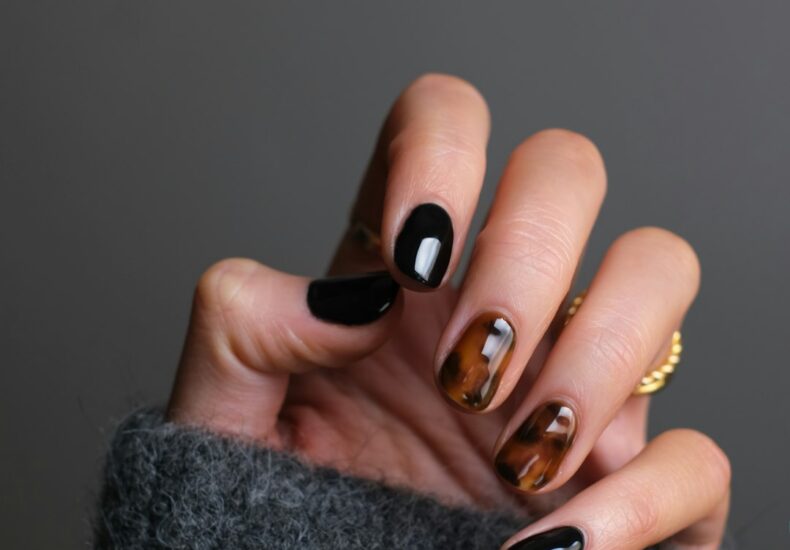 person wearing gold ring holding black textile