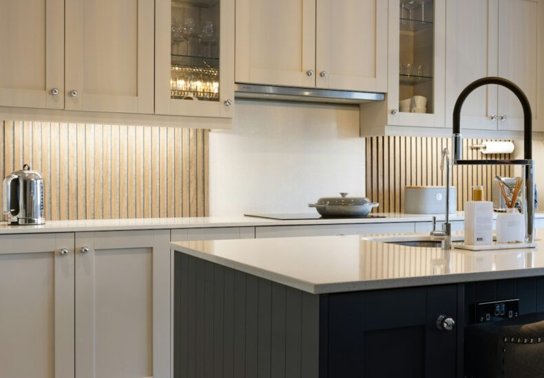 a kitchen with white cabinets and a black island