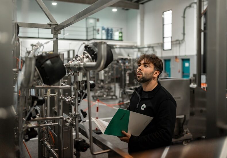 A man inspects machinery in a factory.