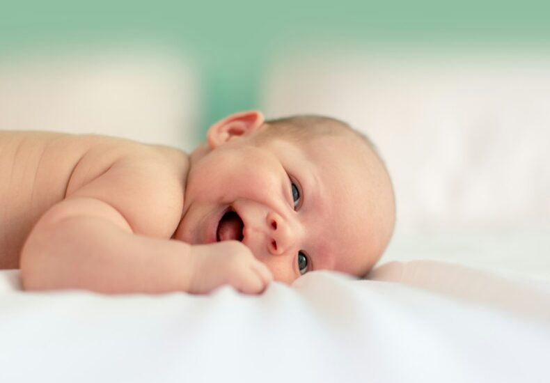baby lying on fabric cloth