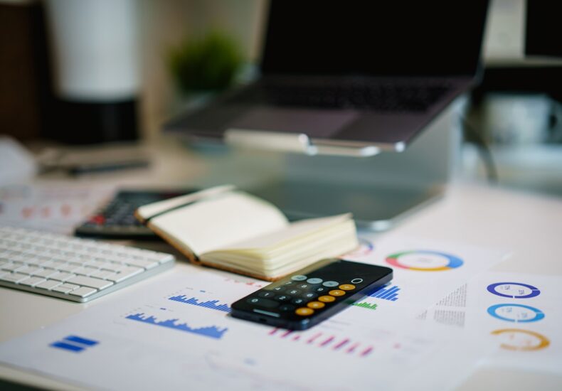 office desk with smartphone and financial charts
