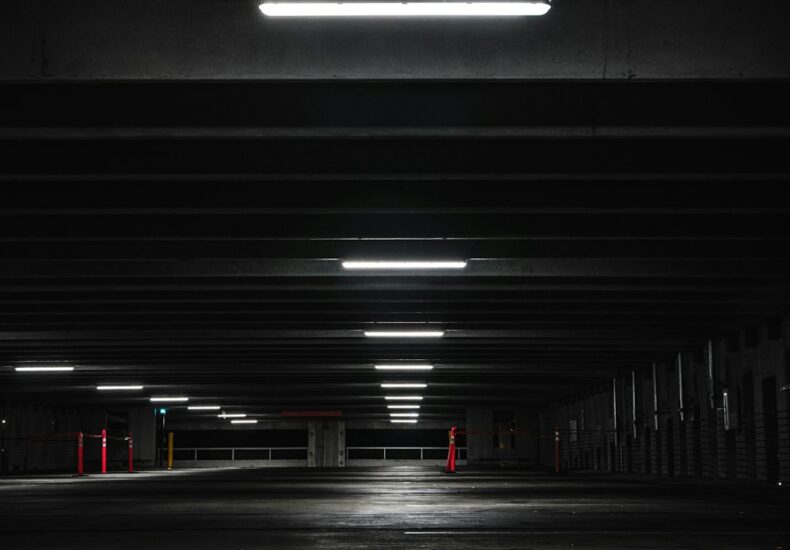 an empty parking garage at night with lights on
