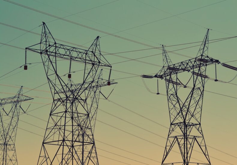 black transmission towers under green sky
