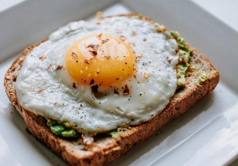 bread with sunny side-up egg served on white ceramic plate