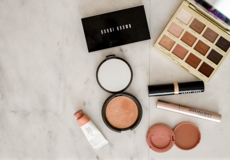 photo of assorted makeup products on gray surface
