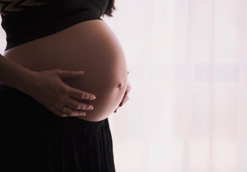 pregnant woman cradling her belly