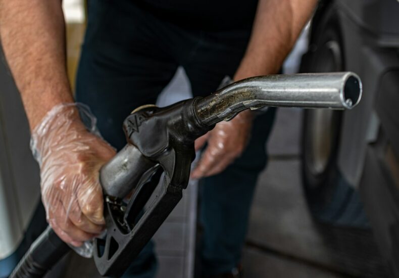 a man pumping gas into a car at a gas station