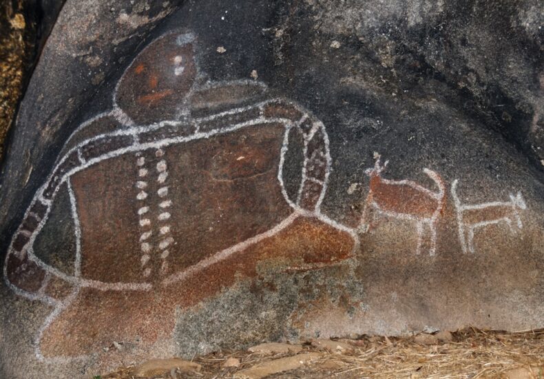 a rock with a painting of a man and a dog on it