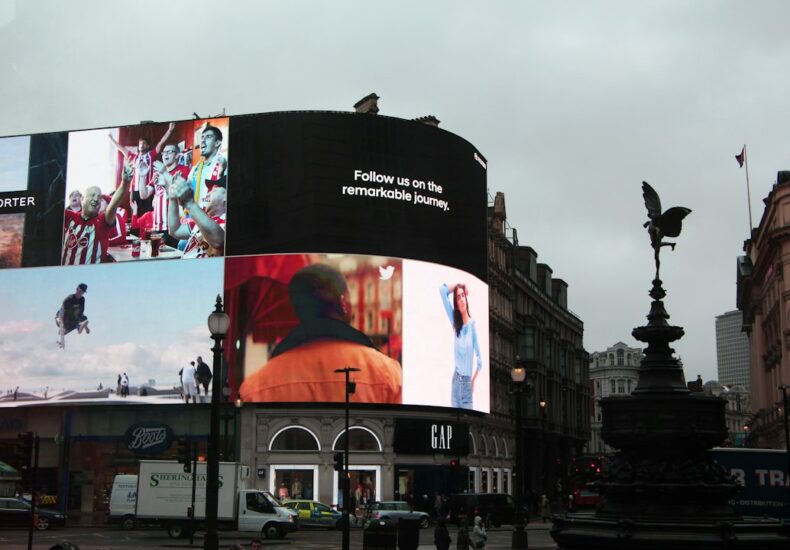 Large digital billboard displaying advertisements above a street corner in London