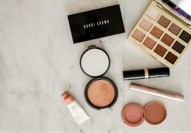 photo of assorted makeup products on gray surface