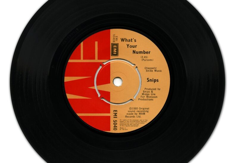 A black vinyl record with a red and orange EMI label